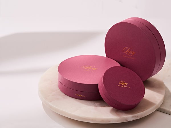 Three Luxy brand hair extension boxes in dark pink packaging.