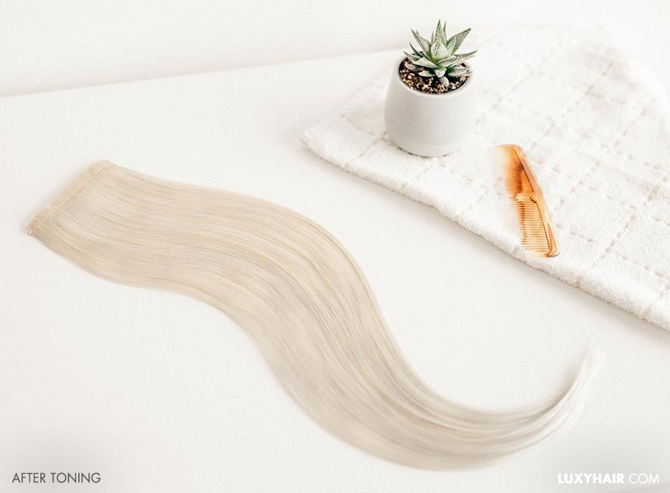 Hair accessories including extensions and a comb on a white towel.