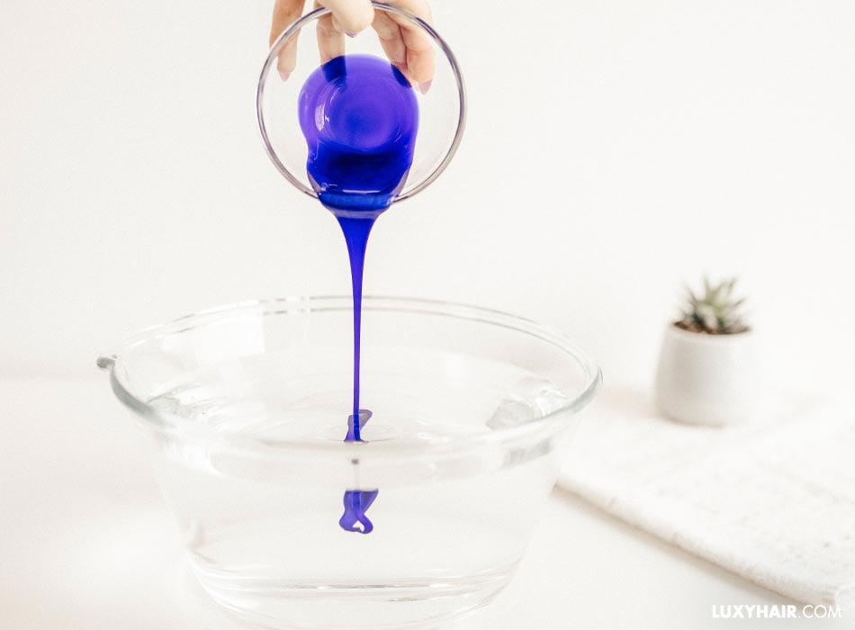 The blue liquid is being poured into a water bowl.